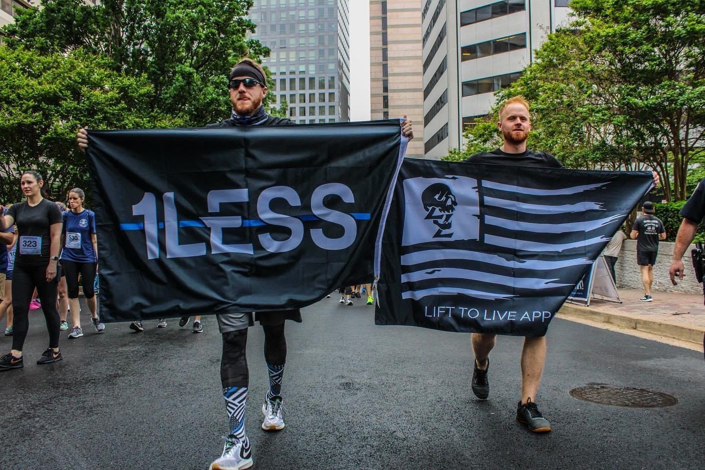 Lift To Live members walking together at a community event, carrying flags