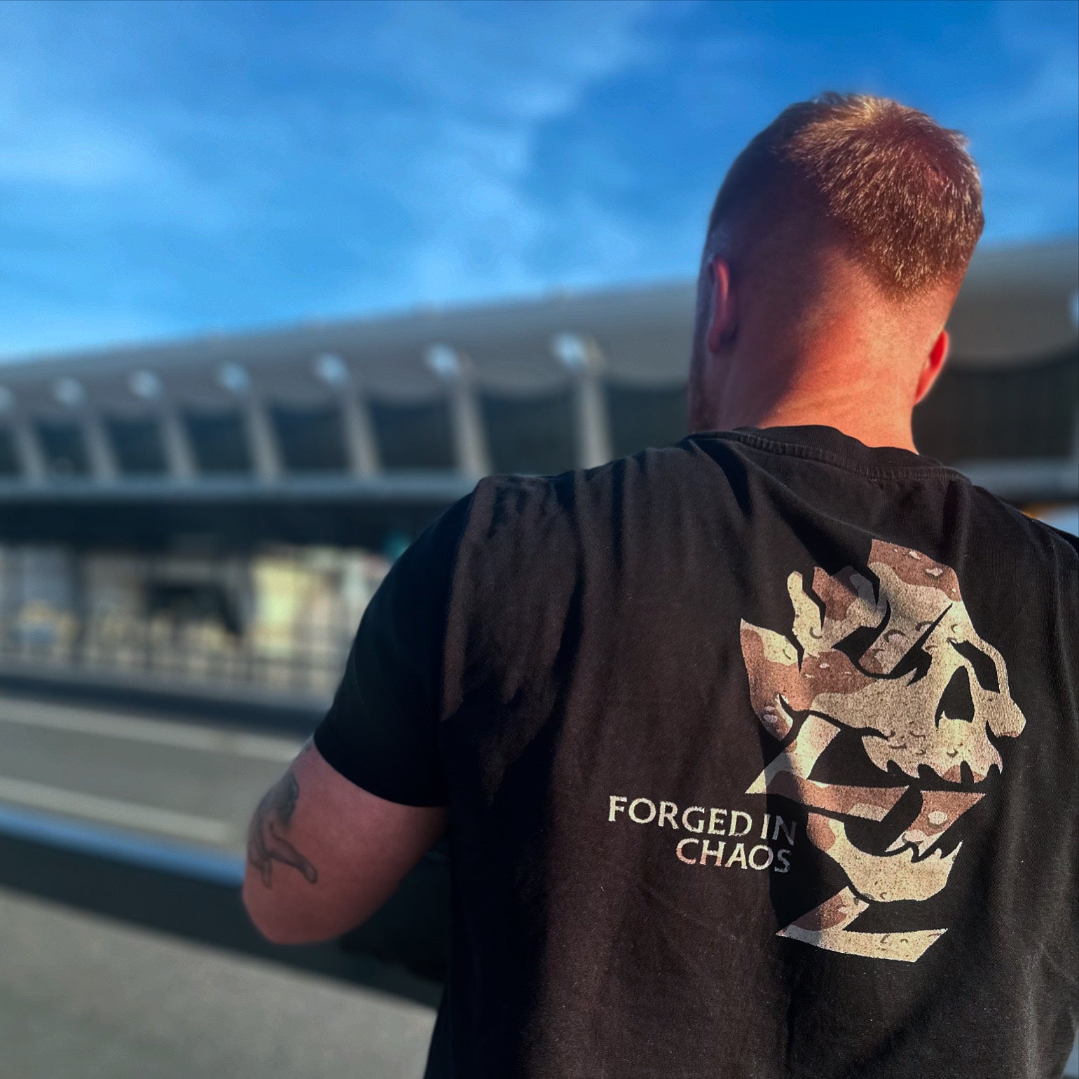 Back view of a person outdoors wearing a Lift To Live Forged In Chaos tee